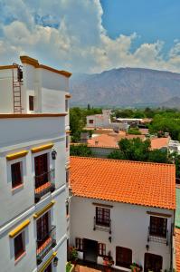 two buildings with orange roofs with a mountain in the background at Hotel Asturias in Cafayate