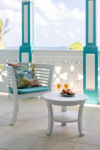 een tafel en een stoel met twee glazen wijn bij Mon Paradis Bleu beach house, 2 bedrooms and sea view! in Saint Martin