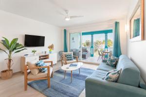 a living room with a blue couch and a tv at Mon Paradis Bleu beach house, 2 bedrooms and sea view! in Saint Martin