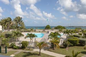 een resort met een zwembad en palmbomen en de oceaan bij Mon Paradis Bleu beach house, 2 bedrooms and sea view! in Saint Martin