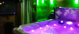 MéolansにあるChalet Espace Lumière - Spa, sauna et salle de fitnessの紫色のバスタブ(照明付)