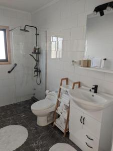 Baño blanco con aseo y lavamanos en Casa Bulnes, en Constitución