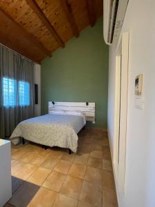 sypialnia z łóżkiem w zielonej ścianie w obiekcie Luxardotel w Rzymie