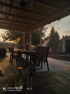 a wooden table and chairs under a pavilion at חאן בכפר במשק בלה מאיה - האוהל in Nevatim