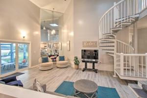 a living room with a staircase and a fireplace at Riverfront Savannah Getaway with Pool and Dock! in Savannah