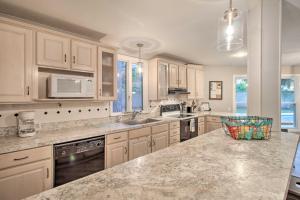 a kitchen with white cabinets and granite counter tops at Riverfront Savannah Getaway with Pool and Dock! in Savannah