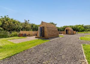 a tiny house in a garden with a gravel driveway at Sandy Park in Trimdon