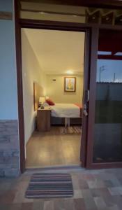 vista su una camera con letto attraverso una porta scorrevole in vetro di Hotel Vista Verde a Huancayo