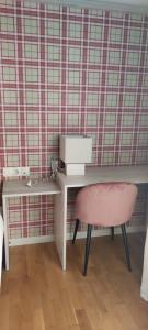 escritorio y silla rosa en una habitación en BAMBOO IV - tucasaenlospirineos, en Escarrilla