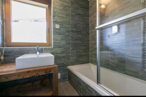 La salle de bains est pourvue d'un lavabo, d'une baignoire et d'une fenêtre. dans l'établissement Avoriaz: superbe appartement de près de 70m2 !, à Avoriaz