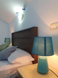 una lámpara azul en una mesa junto a una cama en Tres Caravelas Studio Flats, en Santa Maria