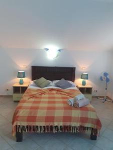 1 dormitorio con 1 cama con 2 lámparas y 2 mesas en Tres Caravelas Studio Flats, en Santa Maria