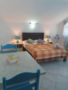 a bedroom with two beds and a table and two chairs at Tres Caravelas Studio Flats in Santa Maria