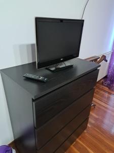 a black dresser with a television on top of it at M&N apartamento Bilbao in Bilbao