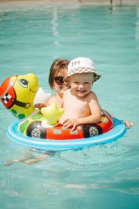 a woman and a baby on a raft in the water at Готель Гармонія. Термально-оздоровчий комплекс. in Mynay