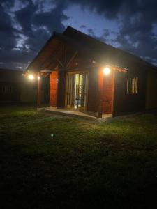 uma pequena casa à noite com luzes acesas em Cabana Furna dos Pôneis em Urubici