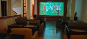 uma pessoa sentada numa cadeira a ver uma apresentação num ecrã em Hotel Shree Tara em Kathmandu