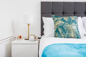 1 cama con almohada azul y blanca y mesita de noche en Lovely 2 Bed House in Grays. en Grays Thurrock