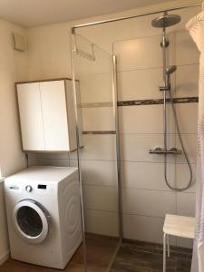 a washing machine in a bathroom with a shower at Ferienhaus-Wiesenblick in Gammendorf