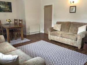 a living room with a couch and a table at Moriston Cottage in Lochcarron