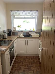a kitchen with a sink and a window at Moriston Cottage in Lochcarron