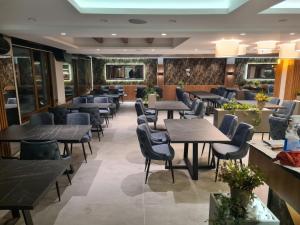 un ristorante con tavoli e sedie in una stanza di President Kop S9, S3 & A102 a Kopaonik
