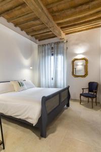 - une chambre avec un grand lit et une chaise dans l'établissement Bolgheri Bramasole, à Bolgheri