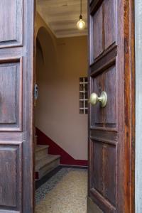 une porte en bois ouverte dans un couloir avec des escaliers dans l'établissement Bolgheri Bramasole, à Bolgheri