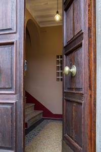 an open wooden door in a hallway with stairs at Bolgheri Bramasole in Bolgheri