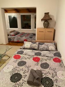 a bedroom with a bed with a flowered bedspread at Elda Hills Apartment in Sarajevo