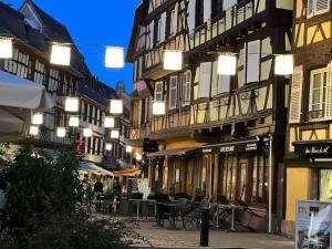 un grupo de edificios con mesas y sillas en una calle en Le nid cosy d'Obernai /2min centre ville/parking en Obernai