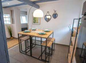 - une salle à manger avec une table et des chaises en bois dans l'établissement Le nid cosy d'Obernai /2min centre ville/parking, à Obernai