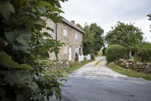 an old stone house on a dirt road at Winsbury Cottage in West Hauxwell