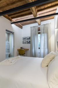 - une chambre avec un grand lit blanc et une fenêtre dans l'établissement Bolgheri Bramasole, à Bolgheri