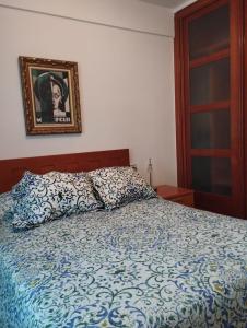 1 dormitorio con 1 cama con edredón azul y blanco en Apartamento Valderas Madrid, en Alcorcón