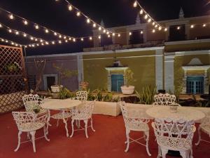 a patio with tables and chairs and lights at Hotel Residencial Edzná Calle 10 in Campeche