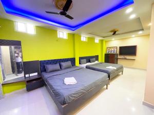 a bedroom with two beds and a blue ceiling at ojotrip Hotel Basanti INN- puri in Puri