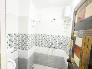 ein Bad mit einem WC und einer Dusche in der Unterkunft ojotrip Hotel Basanti INN- puri in Puri