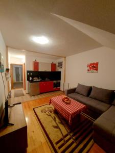 een woonkamer met een bank en een tafel bij Guesthouse Kusić in Kupres