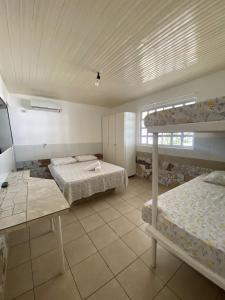 a bedroom with two bunk beds and a table at Beach House Peroba in Maragogi
