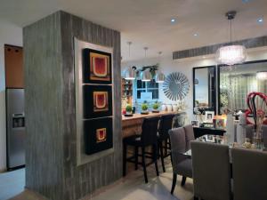 a kitchen and dining room with a bar with chairs at Casa Cristal in Cancún