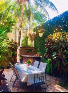 stół i krzesła w ogrodzie z palmami w obiekcie Casa Cristal w mieście Cancún