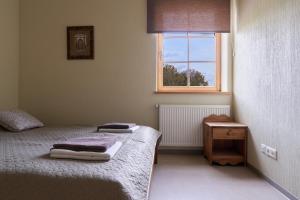 a small bedroom with a bed and a window at Juku Dzirnavas in Zutēni
