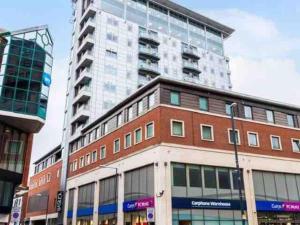 a large building in front of a tall building at Stunning apartment in the heart of Leeds in Leeds