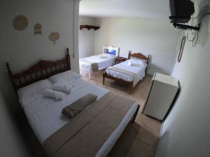 a bedroom with two beds and a mirror in it at Pousada Solar da Montanha in Pedreira