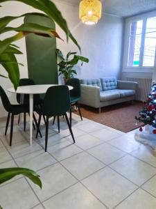 uma sala de estar com um sofá, uma mesa e cadeiras em Bel appartement à 3 min de la plage de 60m² em Saint-Nazaire