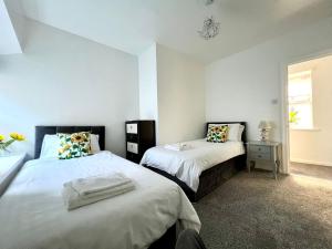 a bedroom with two beds and a window at Angel Lane Alnwick Apartment in Alnwick