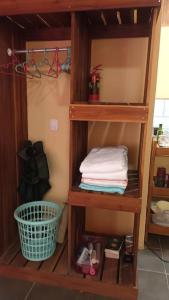 estante de madera con toallas y cesta en una habitación en Casita Olivia en Sámara