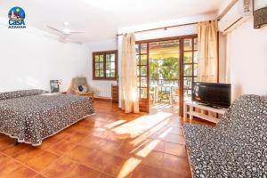 a bedroom with a bed and a tv and a couch at Apartamentos Marino Casa Azahar in Alcossebre