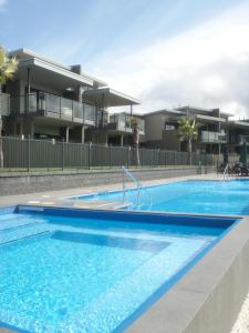 a swimming pool in front of a apartment building at Sovereign Pier On The Waterways in Whitianga